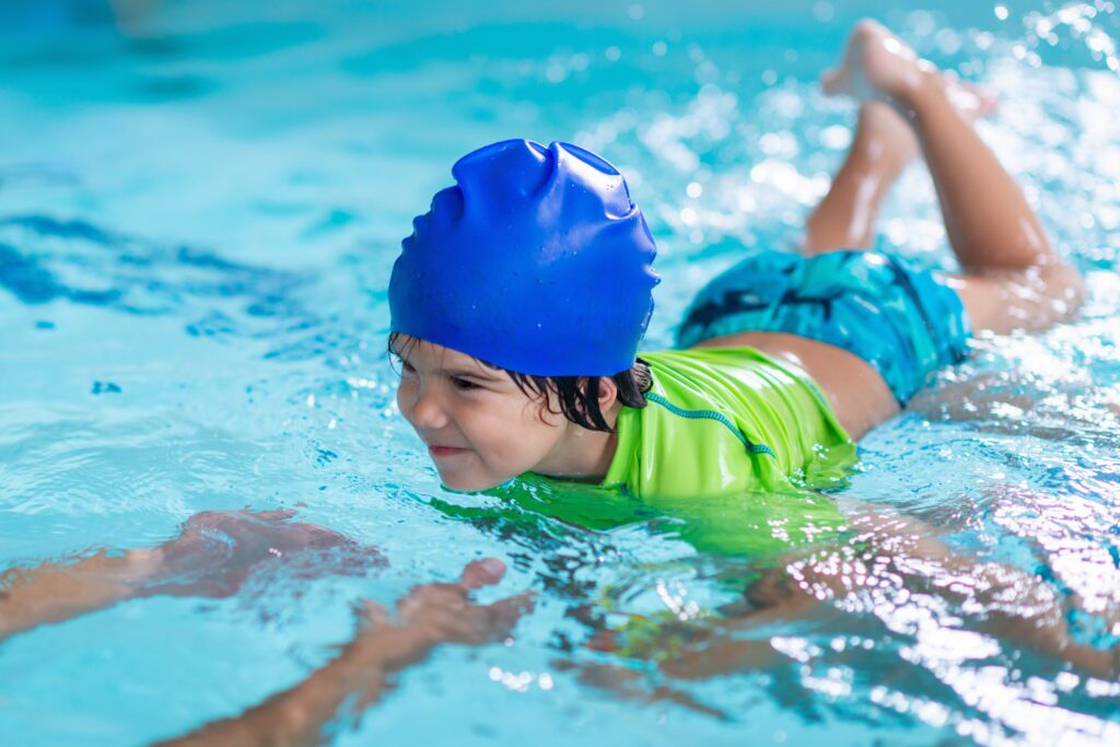 Young child afraid of water is given swimming lessons in pool